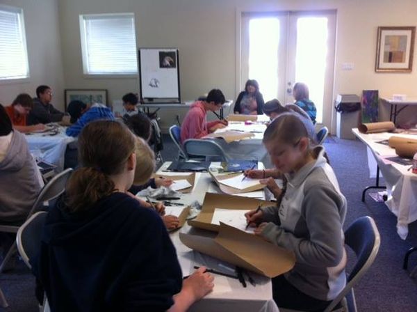 Youth art workshop in progress with students at tables