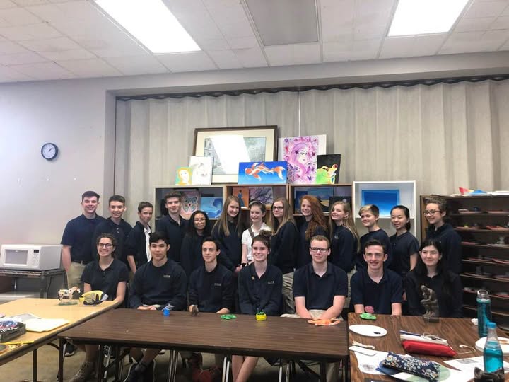 School art class group photo in front of student work